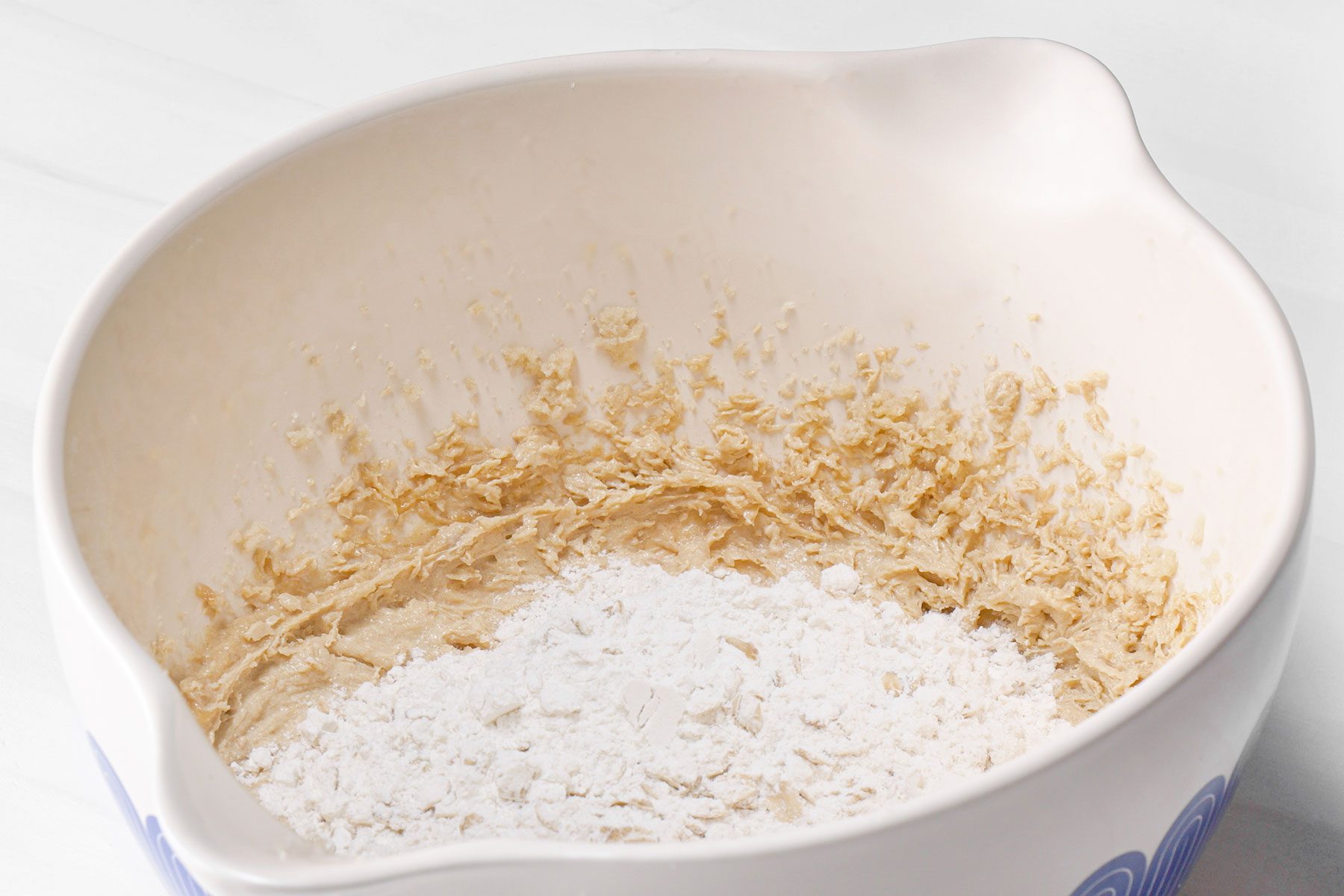 Flour added in in bowl of cookie dough mixture