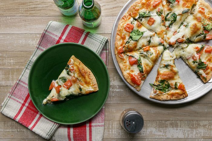 Spinach Pizza slices served on plate with beverage