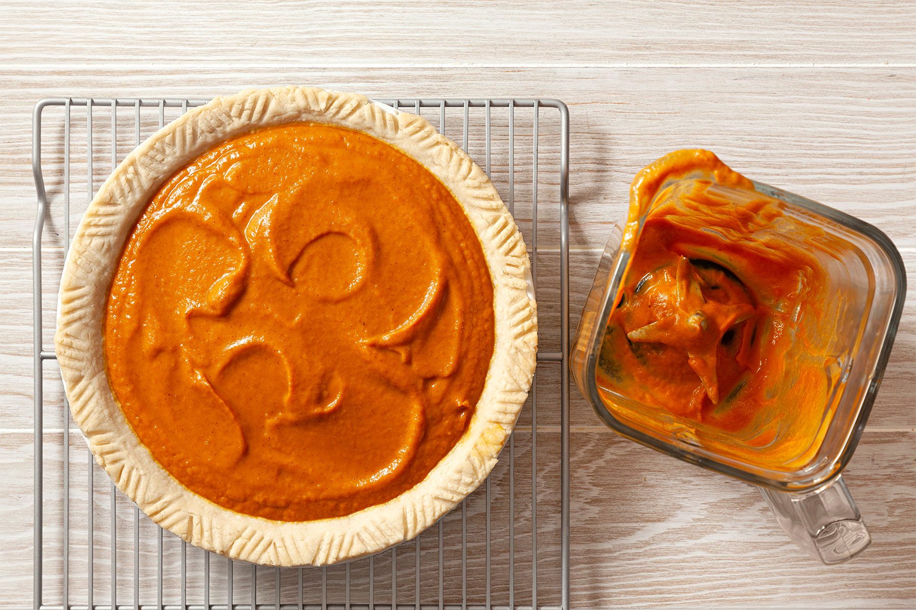 overhead shot; wooden background; poured filling into pie from blender; pie crust over wired rack;