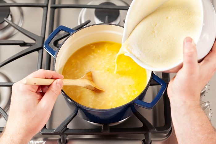 Adding the mixture in pot with rice