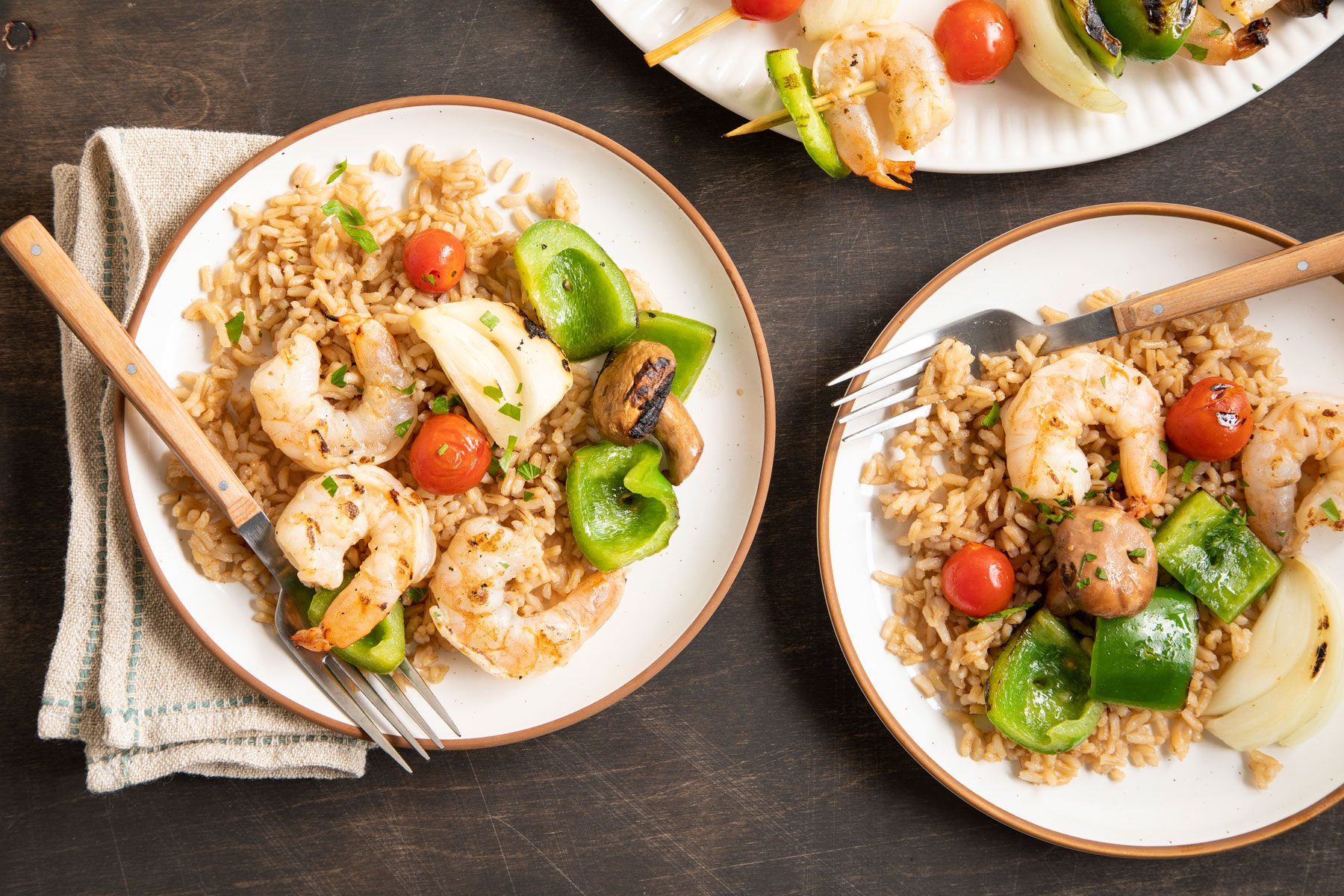 Shrimp Kabobs and brown rice served on a wooden table