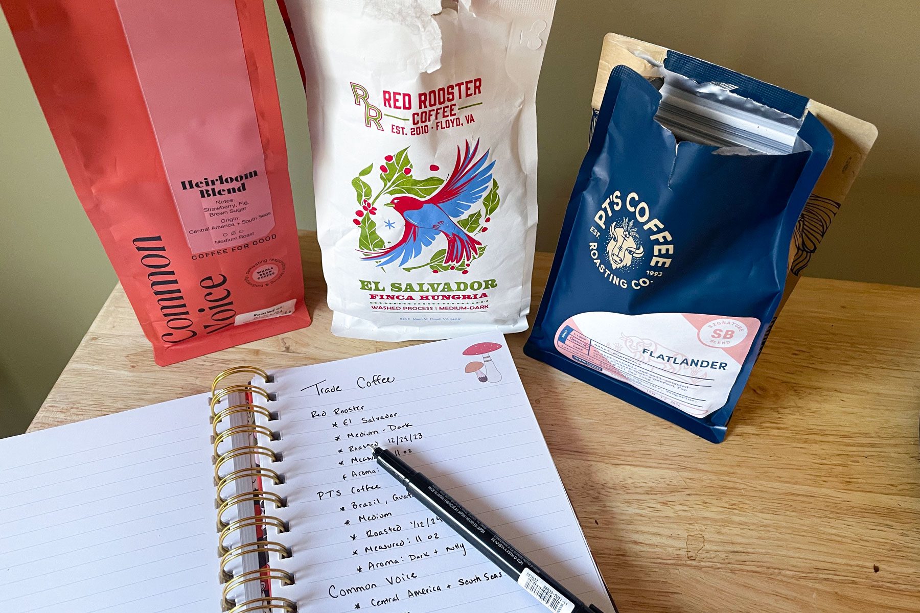 Packs of coffee with a notebook and a pen on a table