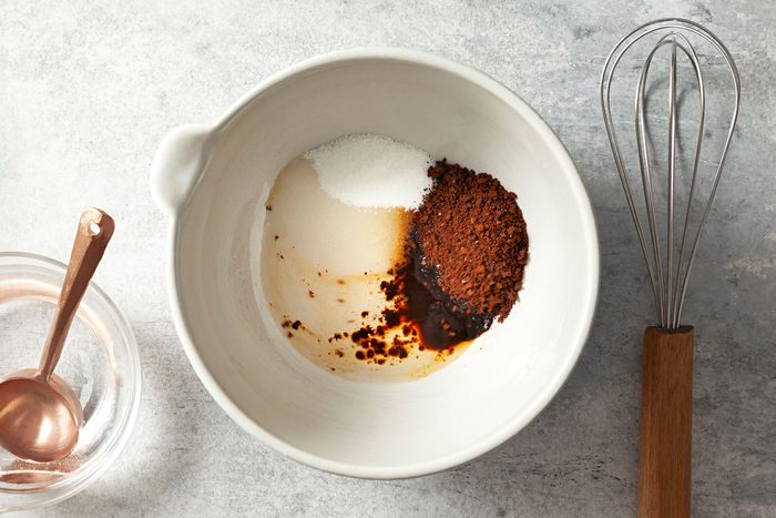 overhead shot of ingredients for Whipped Coffee (Dalgona Coffee) in a large white bowl with a whisker