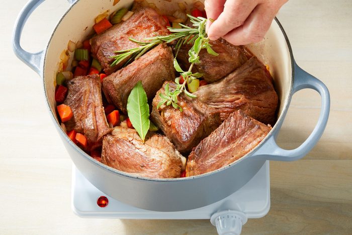 Adding herbs to Dutch oven after ribs have been returned and beef broth has been added