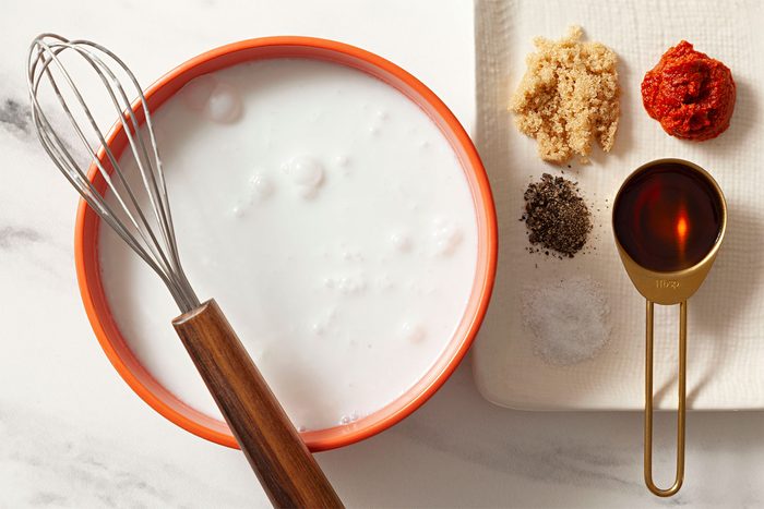 whisking tool kept on the rim of bowl full of milk
