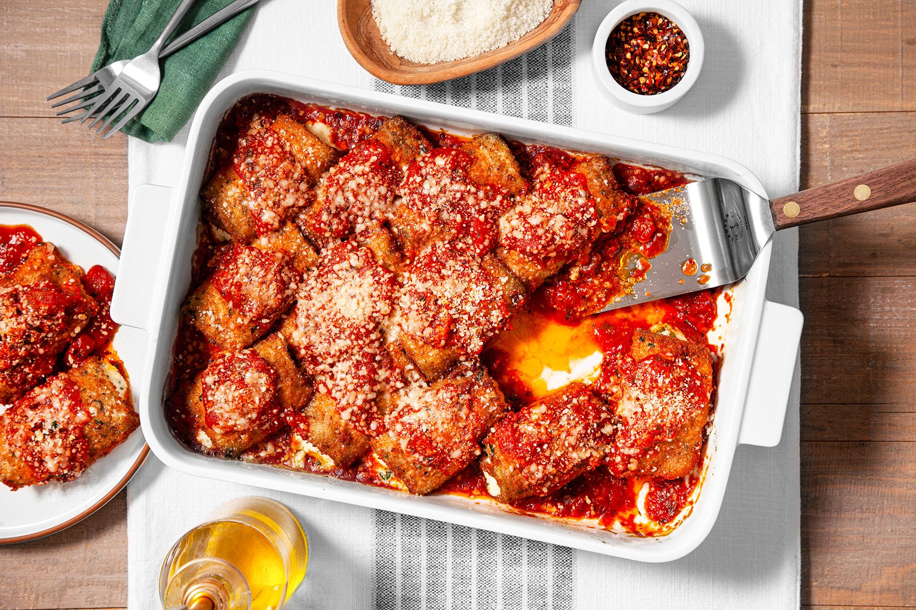 Eggplant Rollatiniin casserole on table runner 