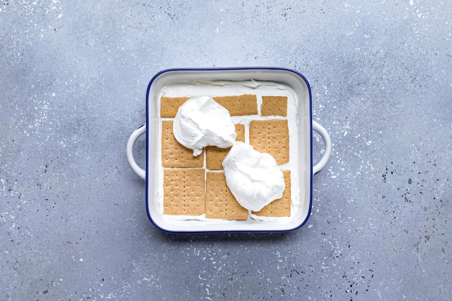 Graham crackers in a large pan topped with cream mixture