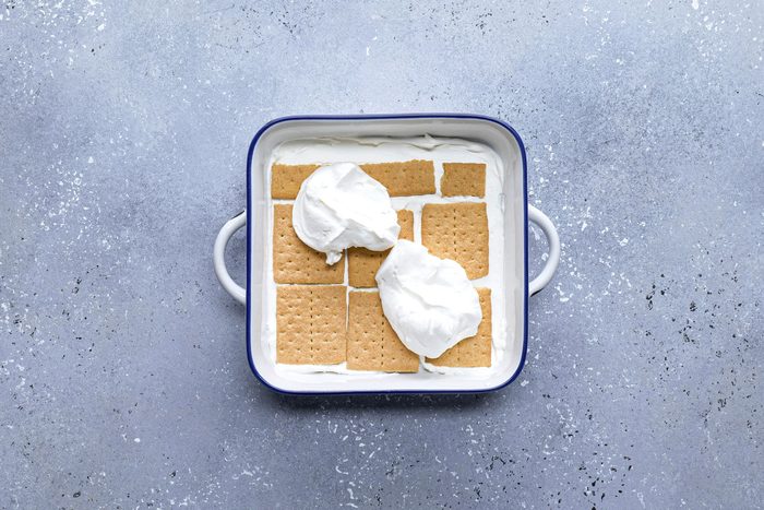 Graham crackers in a large pan topped with cream mixture