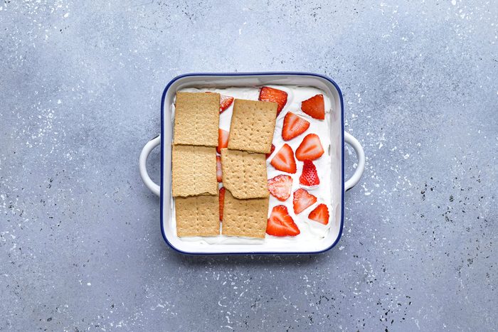 Crackers strawberries and cream mixture in a large pan