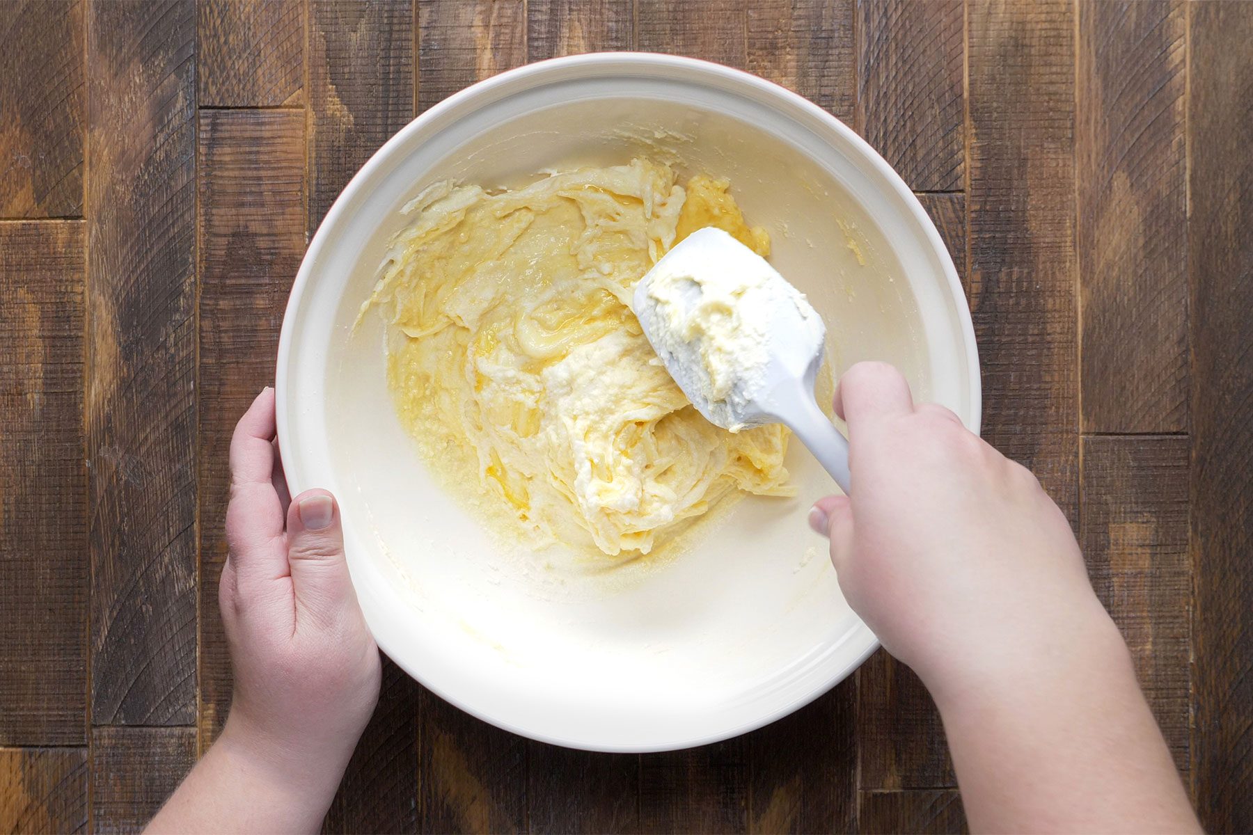 overhead shot of cheese mixture in a bowl; spatula;