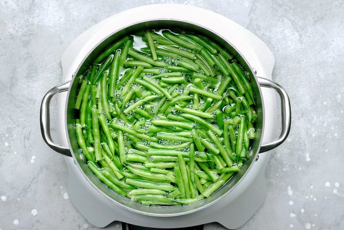 A pot of green beans simmering in boiling water