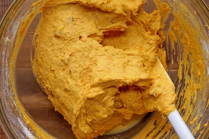 overhead shot of pumpkin cookie batter with spatula in a glass bowl