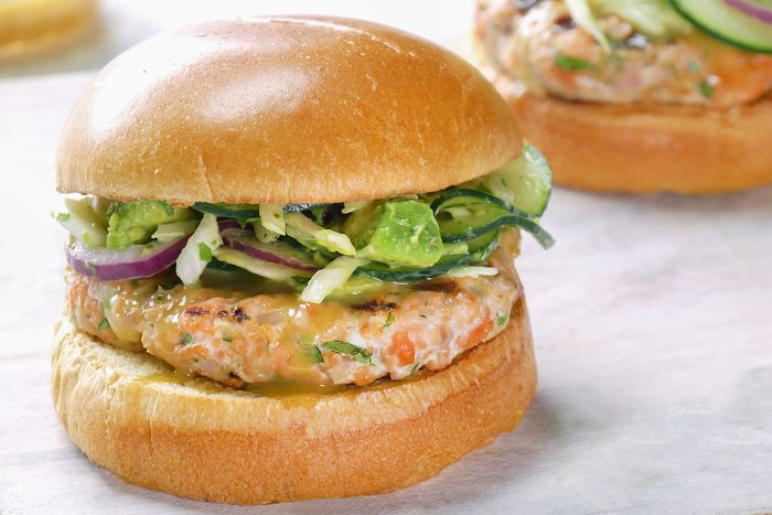 Close shot of Salmon Burgers with Tangy Slaw; wooden board;