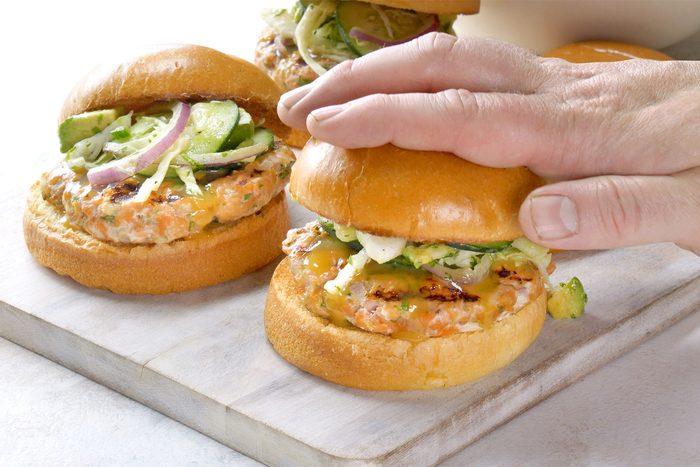 3/4 angle view shot of cover top with buns; wooden board; white marble background;