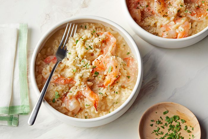 Shrimp Risotto served in a white bowl on marble surface