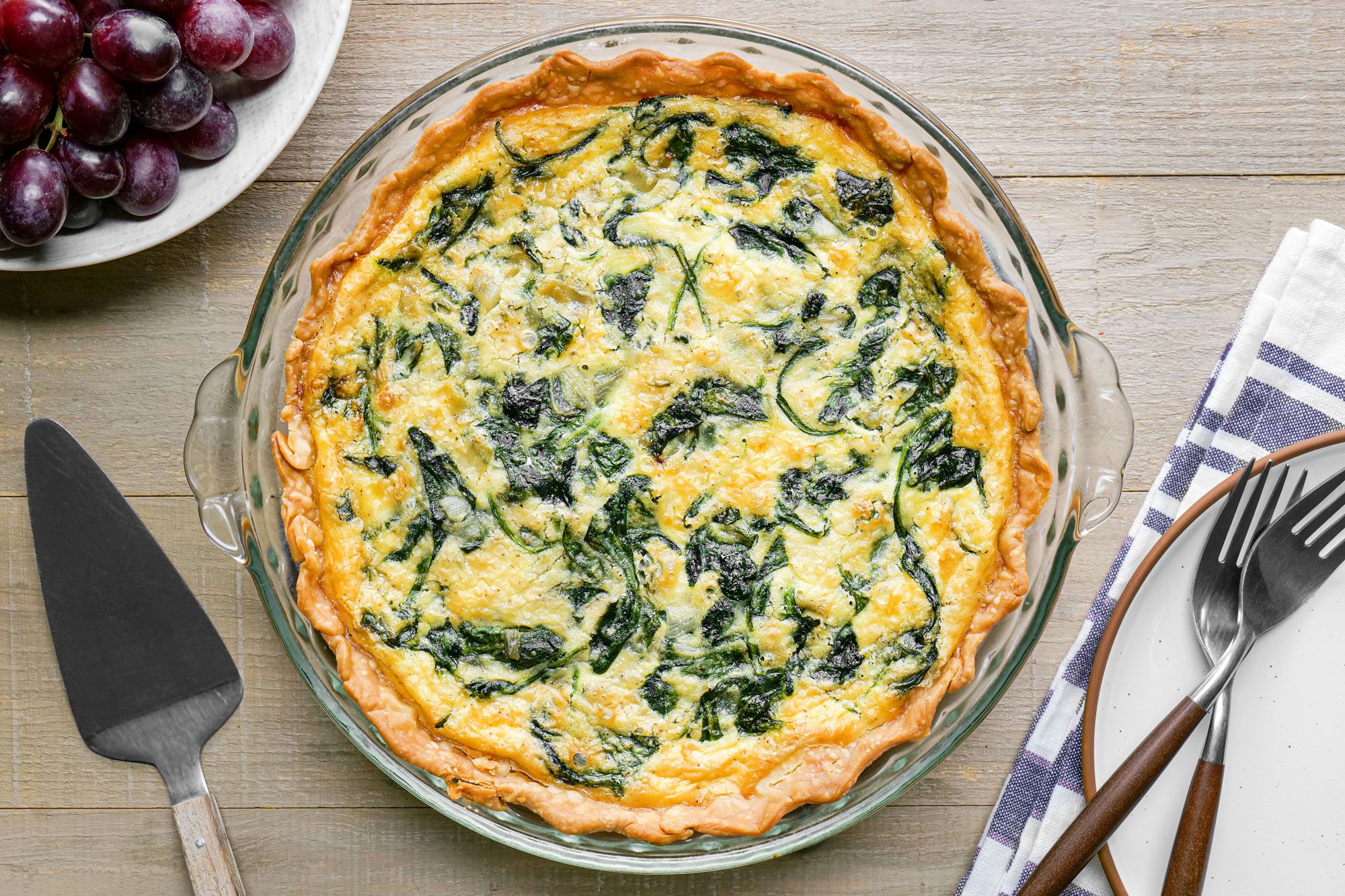 A savory Gruyere Spinach Quiche featuring cheese, placed on a table