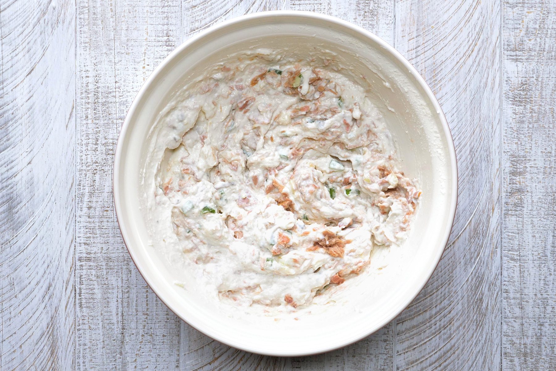 A mixture of sour cream, cheese, milk and salt in a large bowl