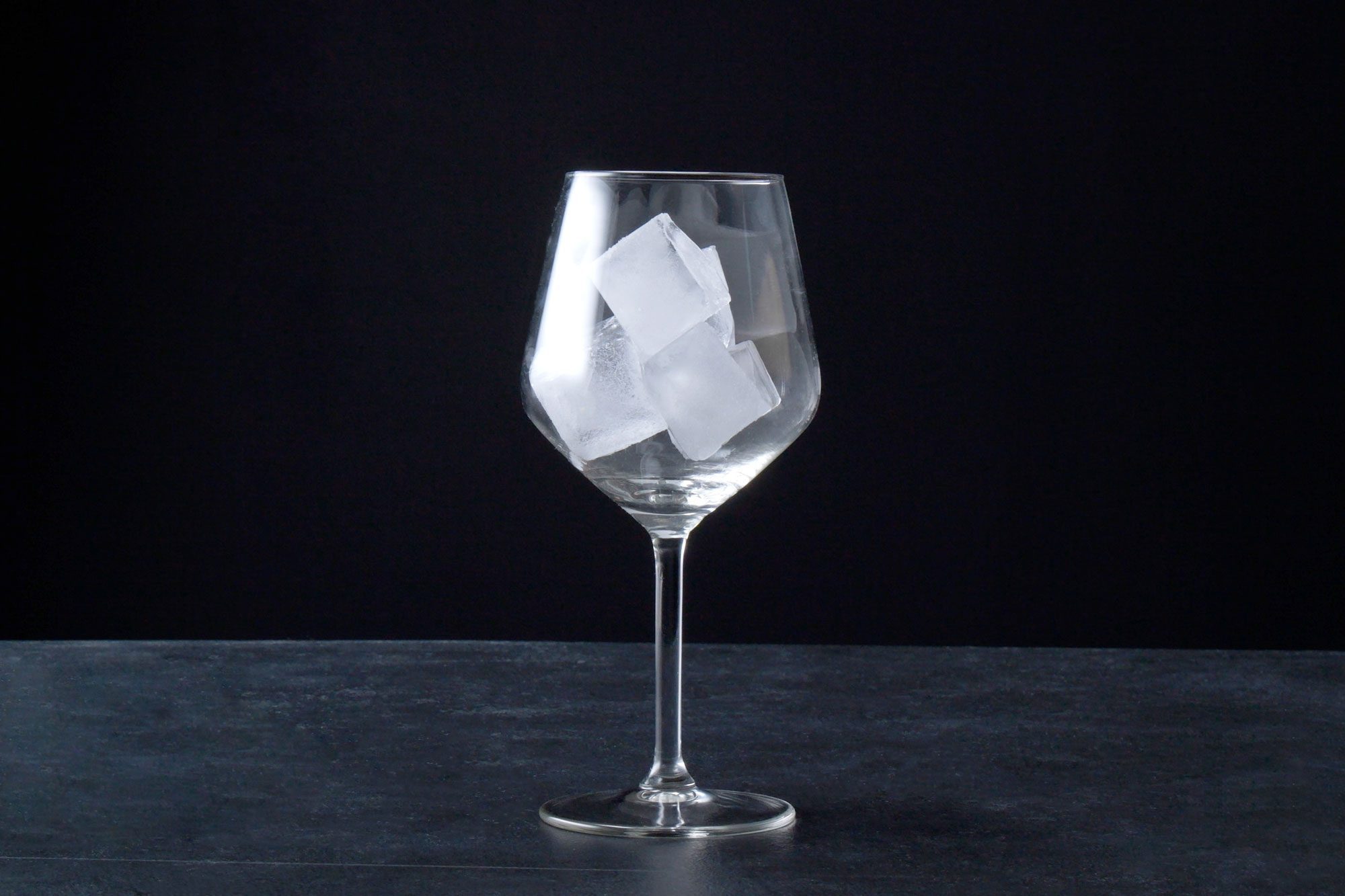 wide shot of large wine glass with ice cubes