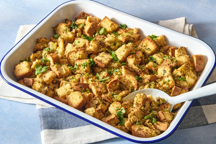 Angled shot of gluten free stuffing being scooped out with a large spoon