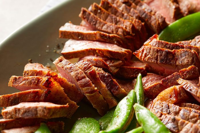 Close shot of Grilled short Ribs; served on platter with beans; marble background