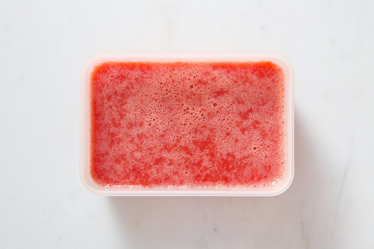 Strawberry ice mixture poured into a freezer-safe container