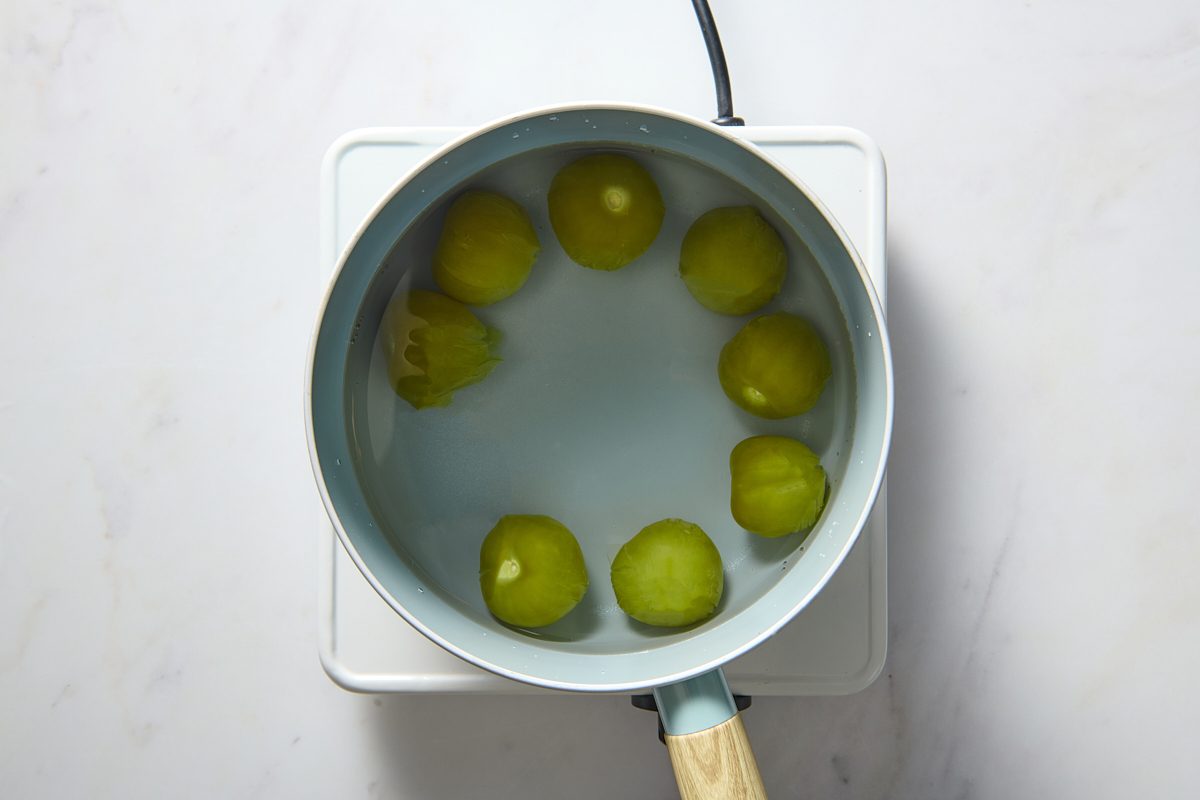 Tomatillos being cooked in a pan