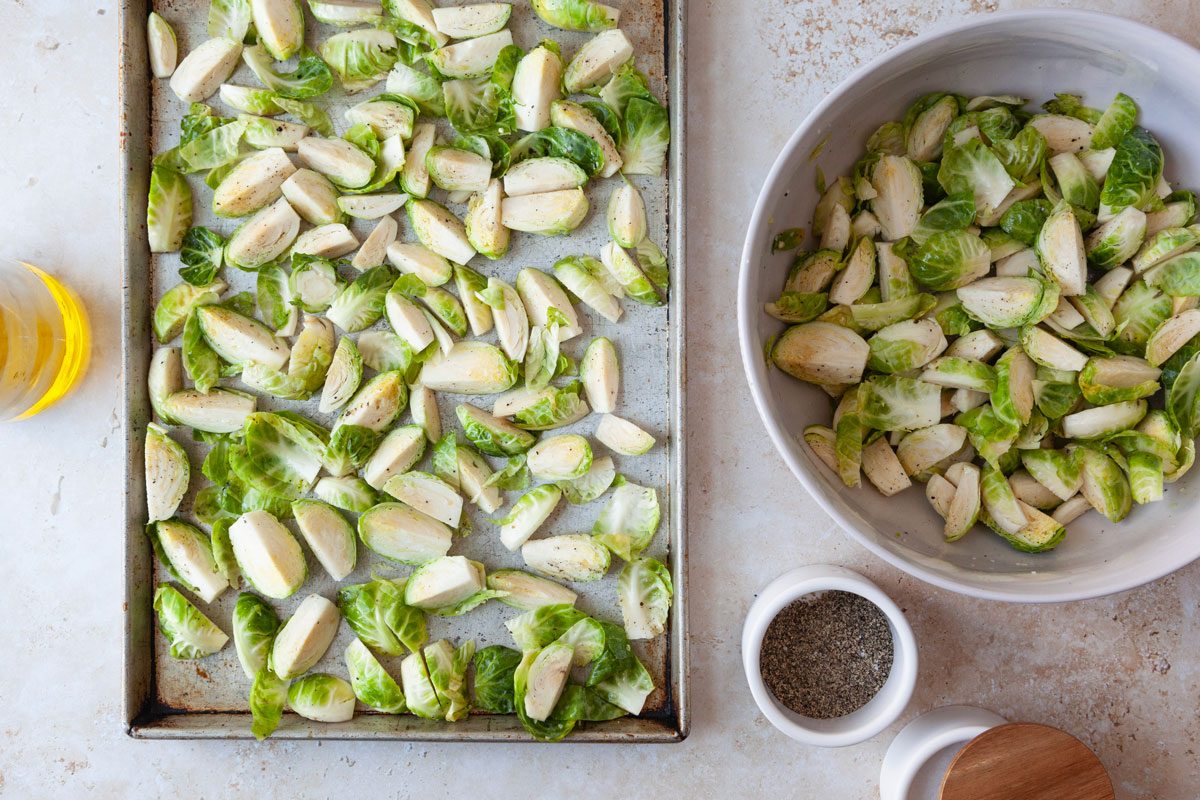 Step 1 of Taste of Home Brussels Sprouts au Gratin is to roast the Brussels sprouts in the oven on a sheet pan with olive oil, salt and pepper