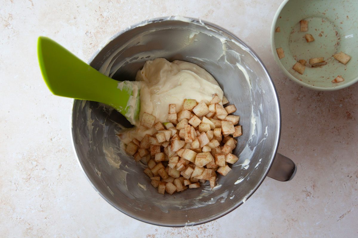 Step 4 of Taste of Home Caramel Apple Cheesecake is to make the cream cheese filling and stir in the cinnamon apple mixture before adding to the crust and baking