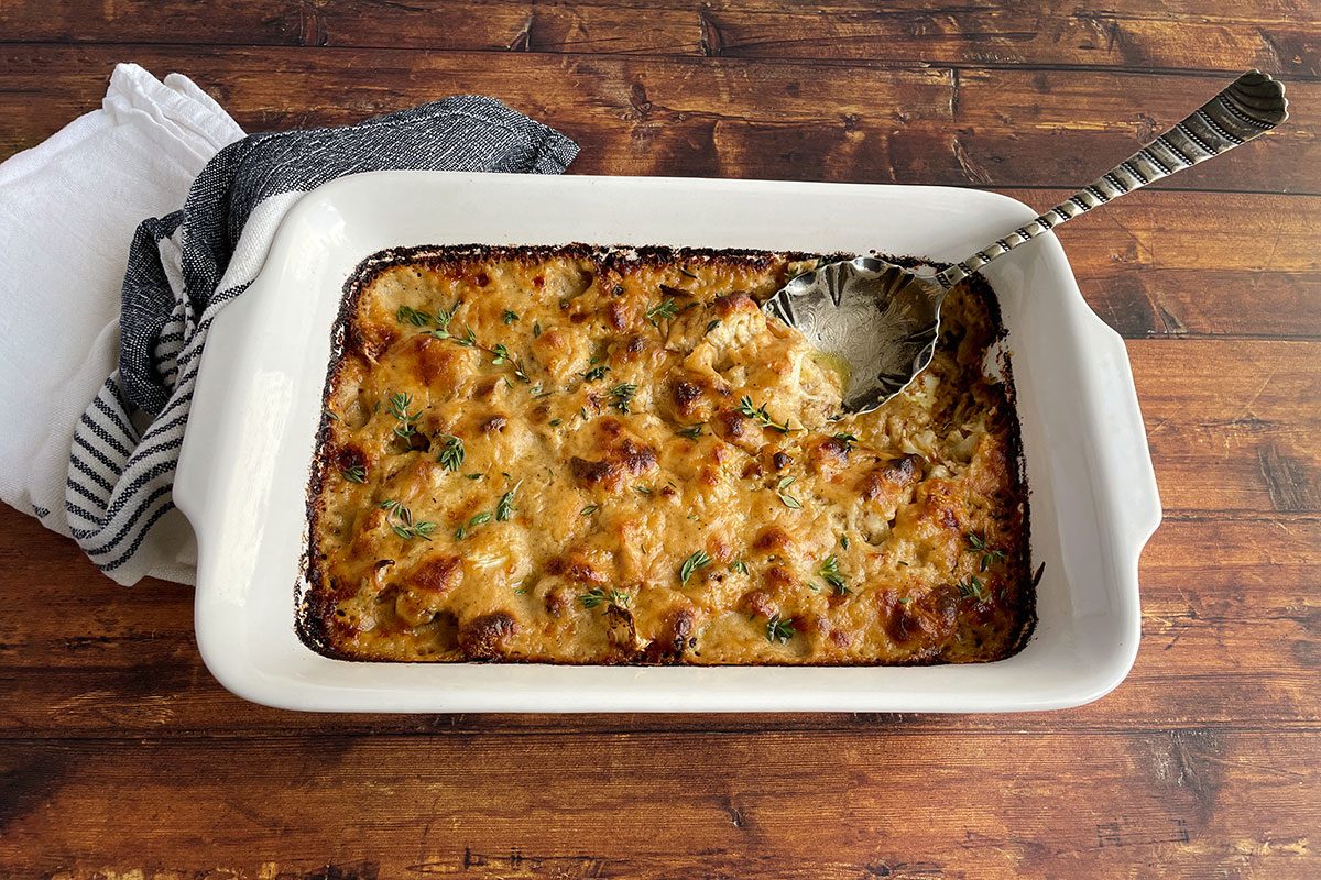 Overhead shot of Taste of Home's Cauliflower Gratin in a baking dish on a dark wood background