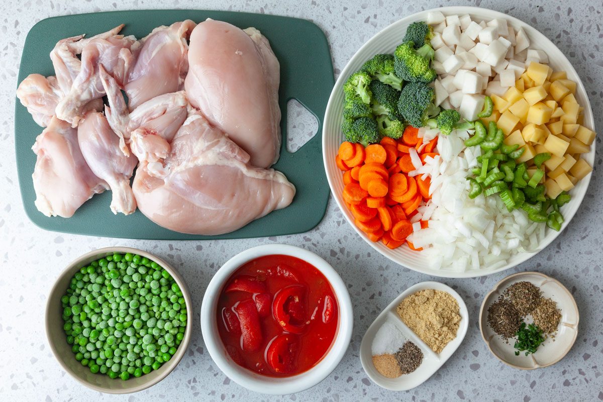 Ingredient shot of Taste of Home Chicken Vegetable Soup inlcuding carrots, onions, broccoli, turnip, potatoes, peas, stewed tomatoes, chicken, seasoning and spices