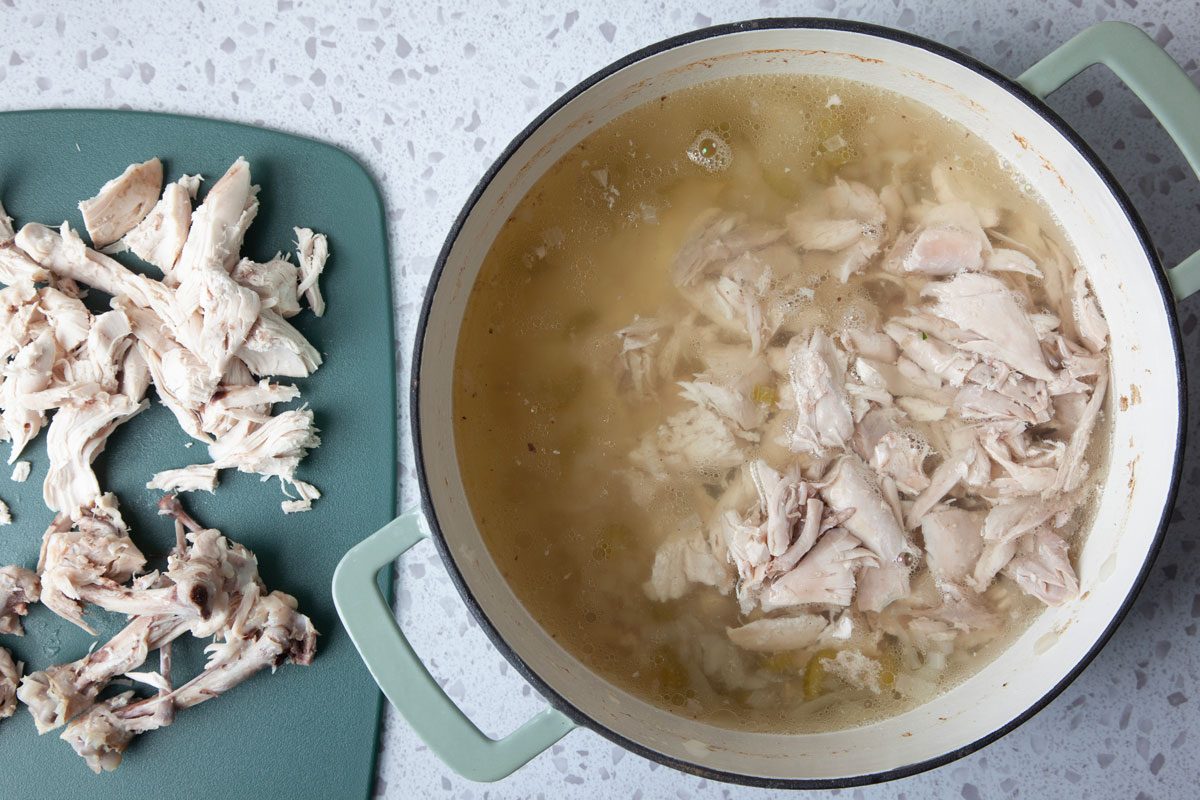 Step 2 of Taste of Home Chicken Vegetable Soup is cutting up the chicken and returning it to the pan with the broth