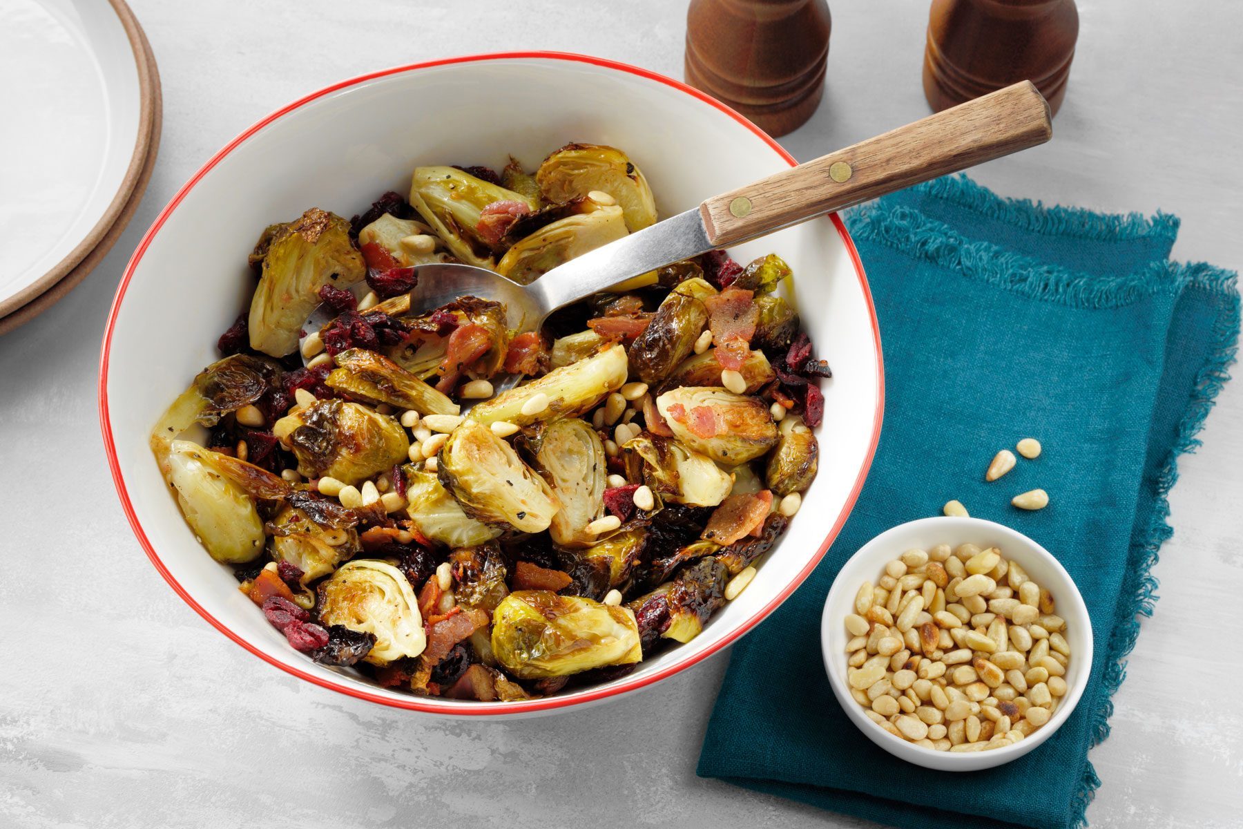 Roasted Balsamic Brussels Sprouts With Pancetta in a serving bowl with a spoon