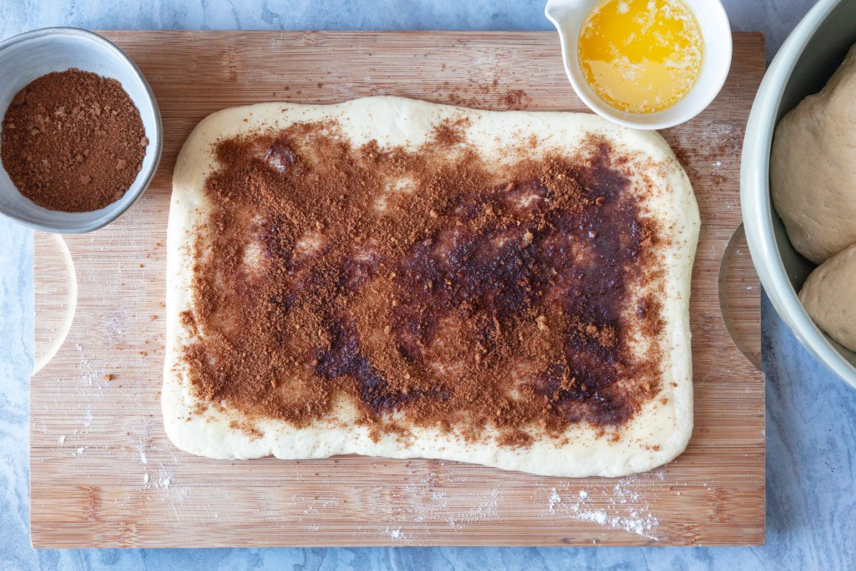 Step 4 of Taste of Home Amish Cinnamon Rolls is to Roll each portion to a 12x8-inch rectangle and spread butter over the dough to within 1/2 inch of the edges. Combine the brown sugar and cinnamon and sprinkle them over the dough.