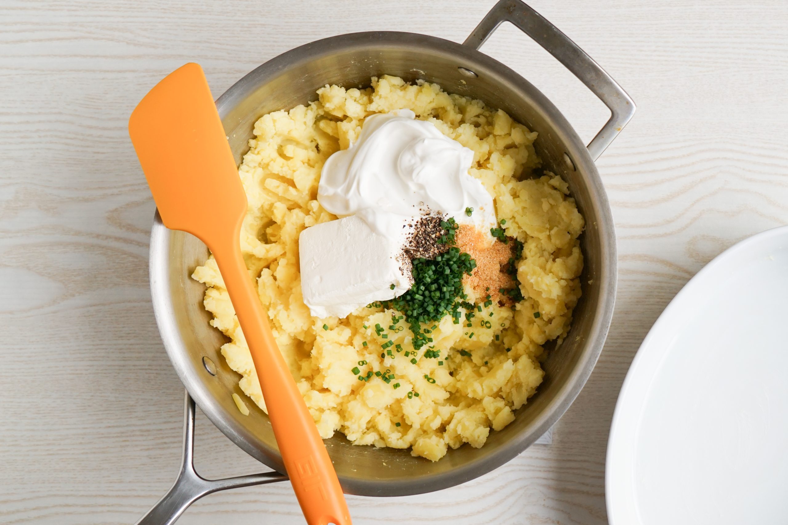 Mixing together the ingredients for baked mashed potatoes