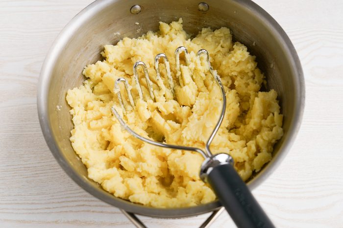 Mashing potatoes in a pot