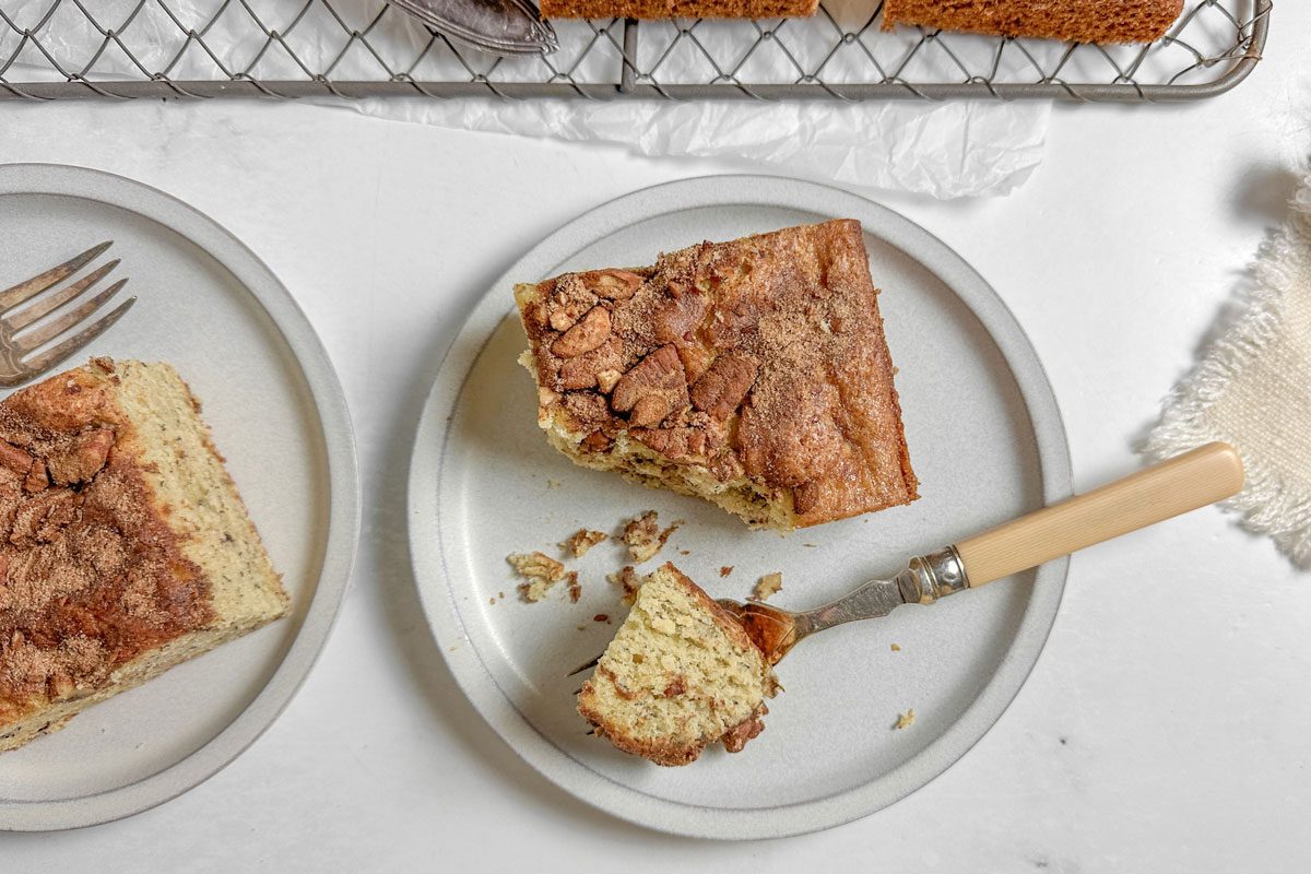 Taste of Home Banana Coffee Cake on wire rack and white plates on a marble surface