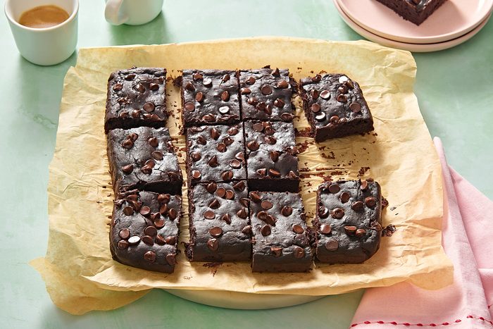 Black bean brownies cut into squares on a piece of parchment paper