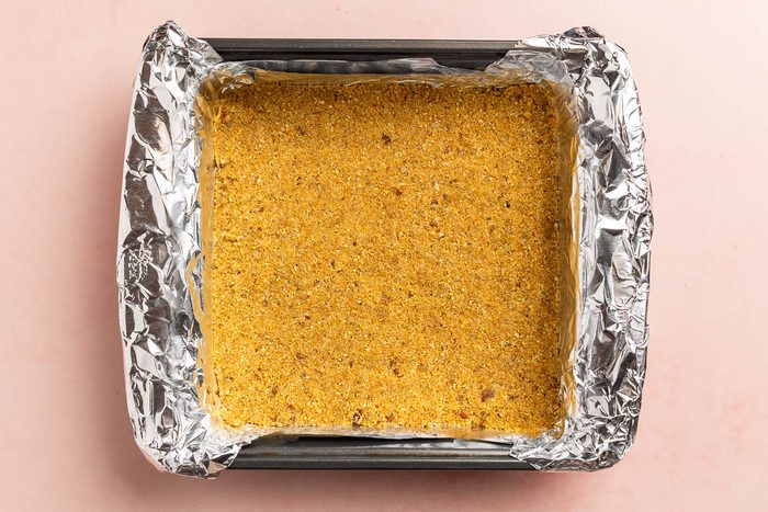 Taste of Home Cheesecake Bites recipe photo of the graham cracker crust in a 9 inch square baking pan.