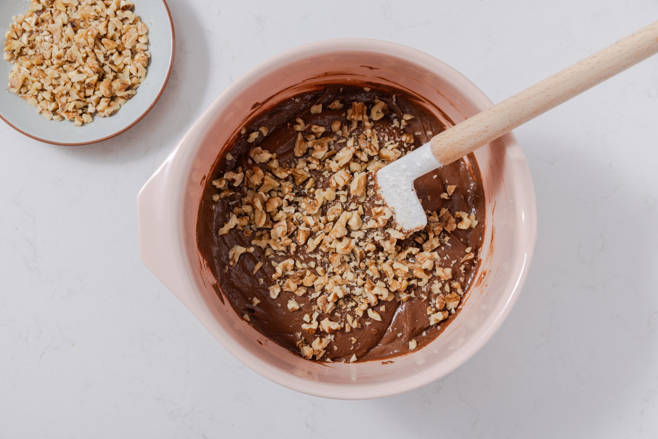 Brownie mix being finalized with walnuts being stirred in.