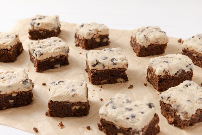 Cookie dough brownies ready, spread in parchment paper.