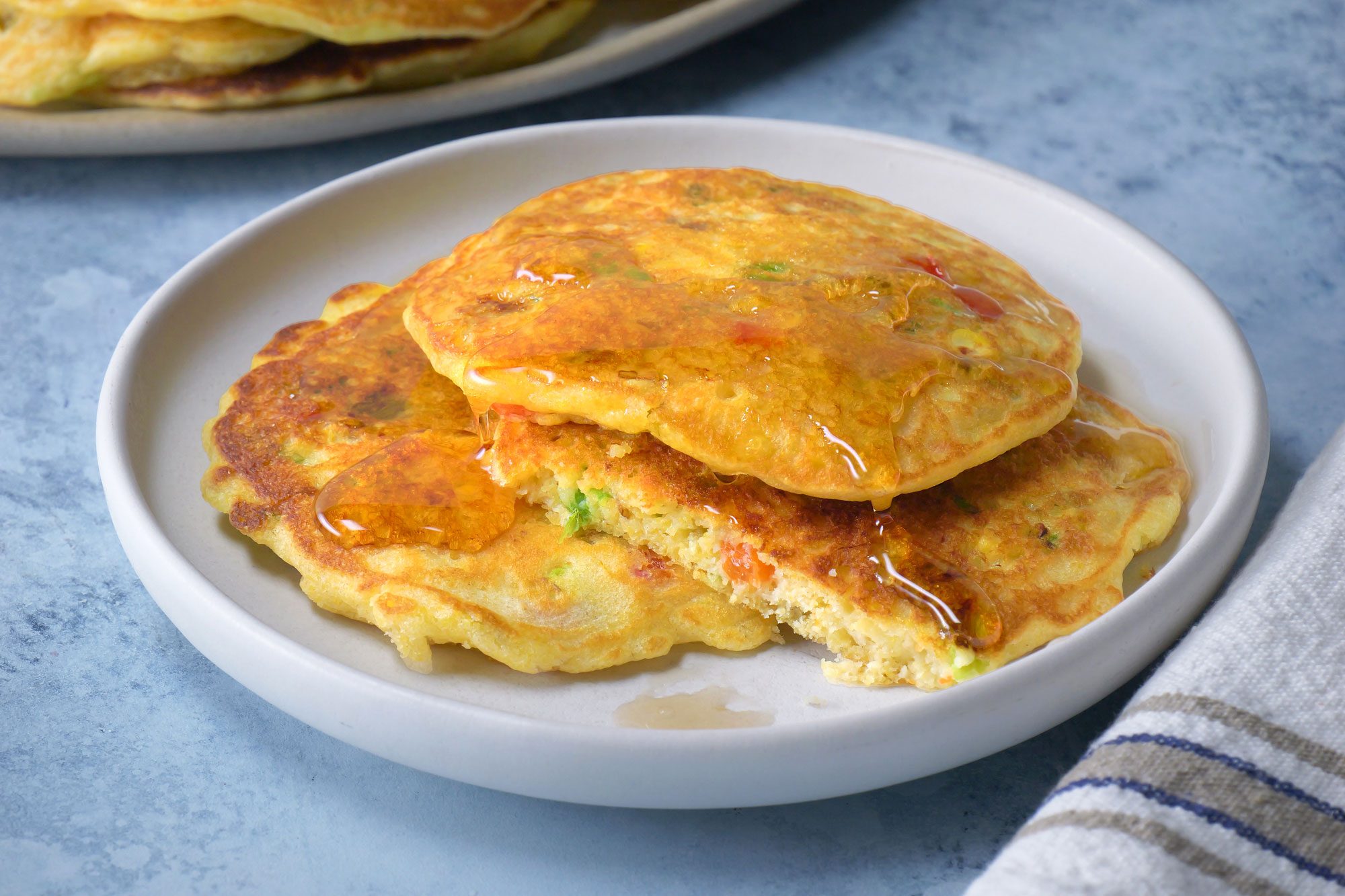 3/4th shot; light blue background; Corn Cakes served on small white plate;