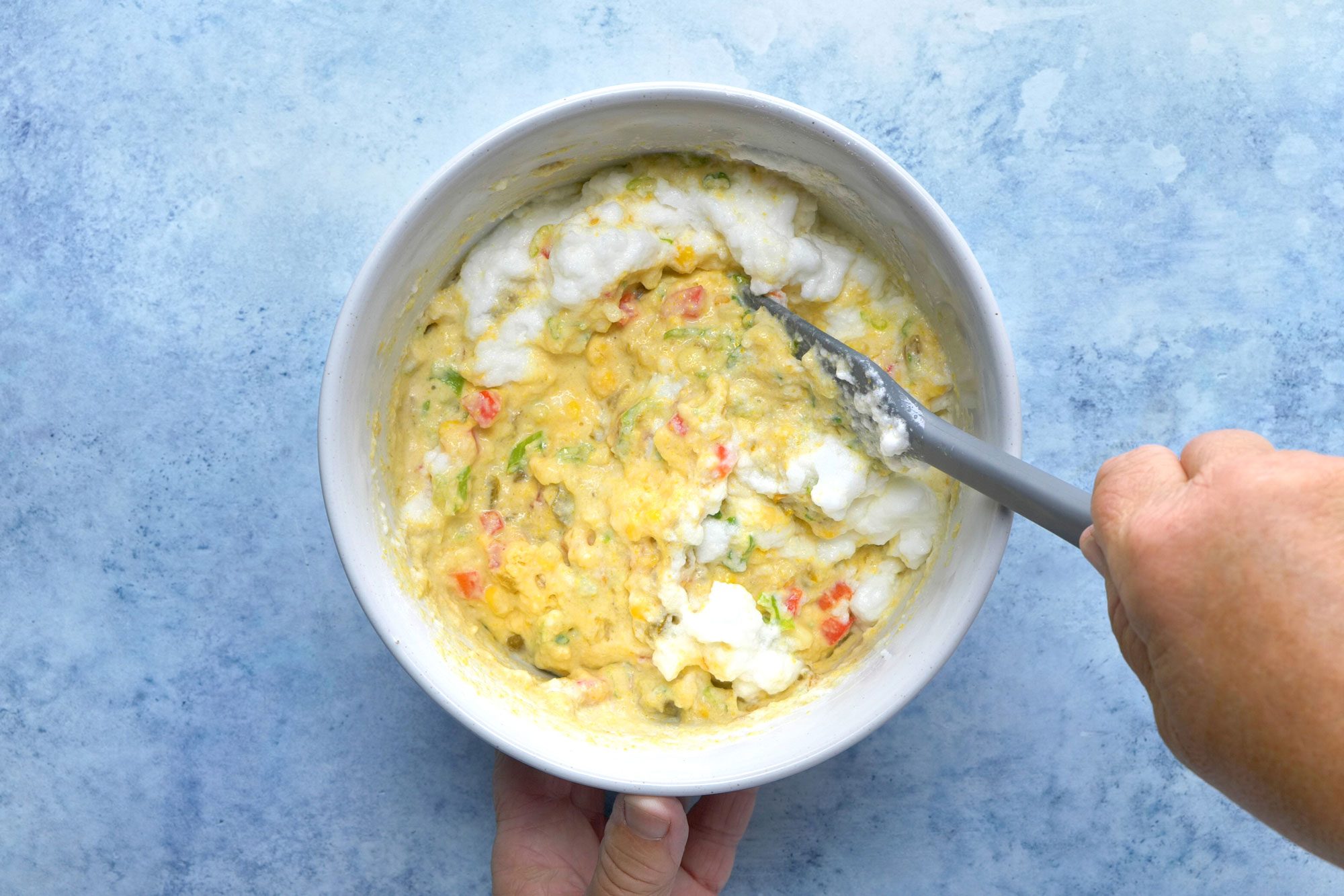 overhead shot; light blue background; added beaten eggs mixture into cake batter;