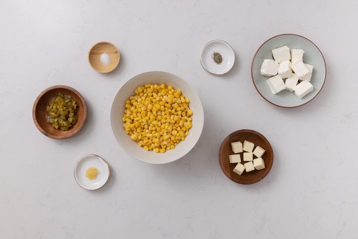 Corn casserole with cream cheese ingredients on kitchen counter.