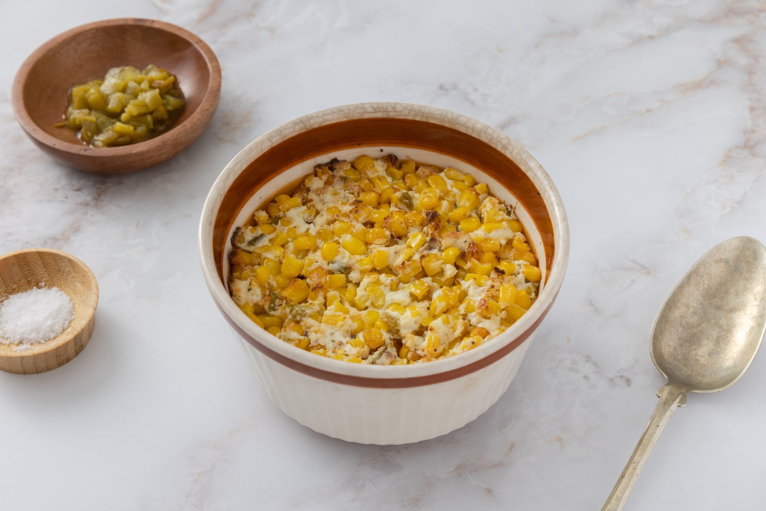 Corn casserole with cream cheese served in baking dish.