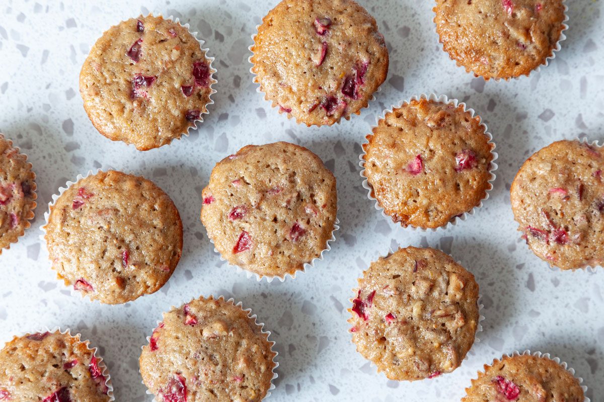 Taste of Home Cranberry Muffins on a marble surface, overhead angle
