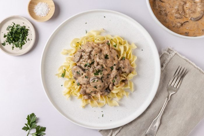 Stroganoff served on plates garnished with fresh parsley.