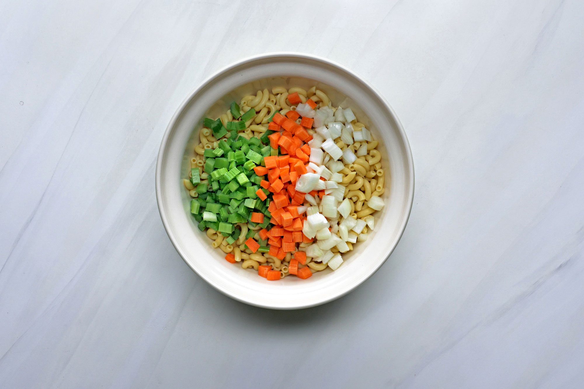 In a large bowl, combine the macaroni, celery, carrot and onion