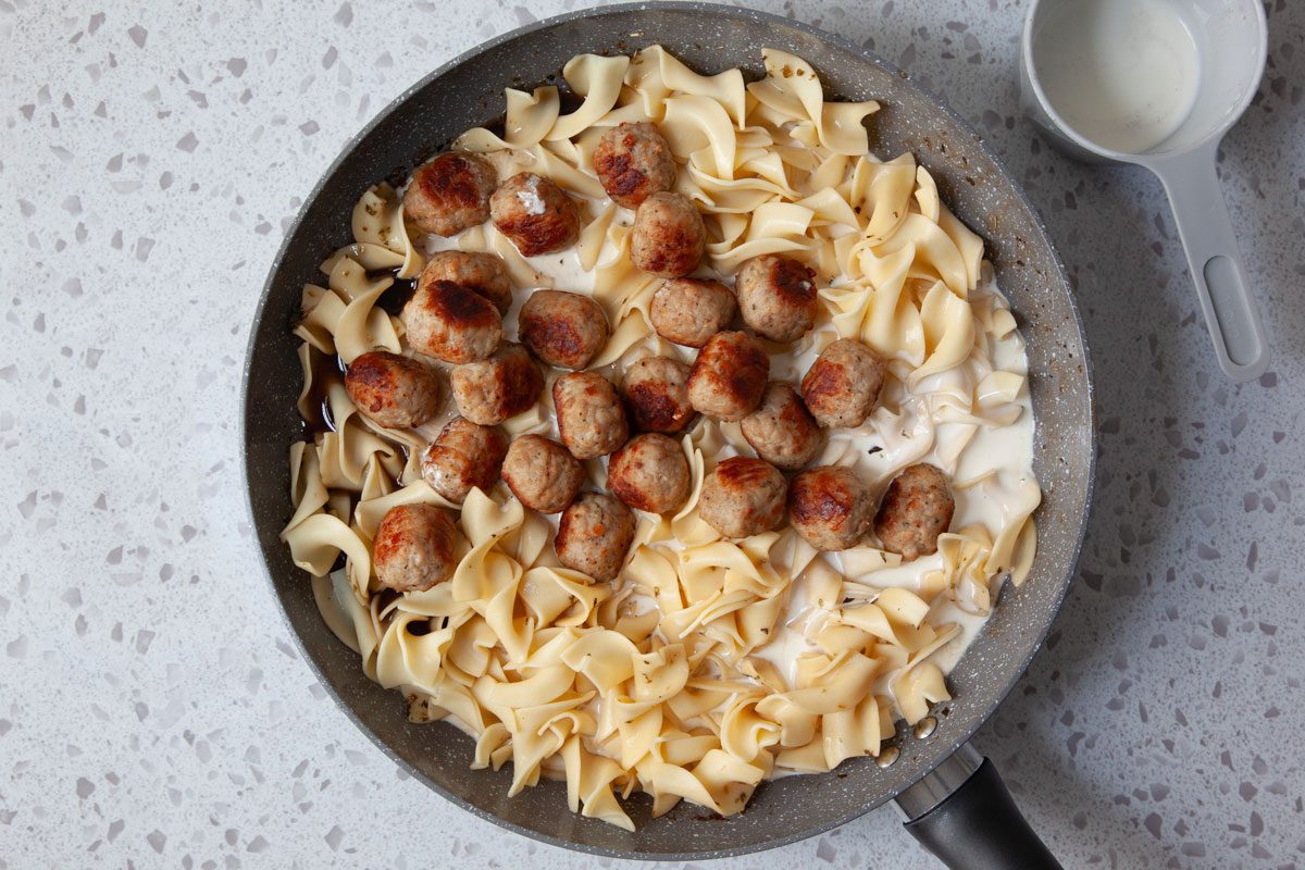 Step 4 of Taste of Home Meatball Stroganoff is to add the meatballs back into the pan along with the noodles and heavy cream and combine