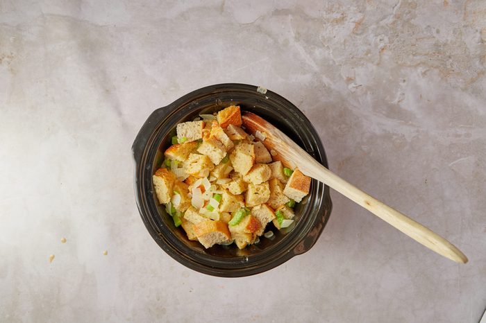 Add the ingredients for vegetarian crockpot stuffing to the slow cooker.