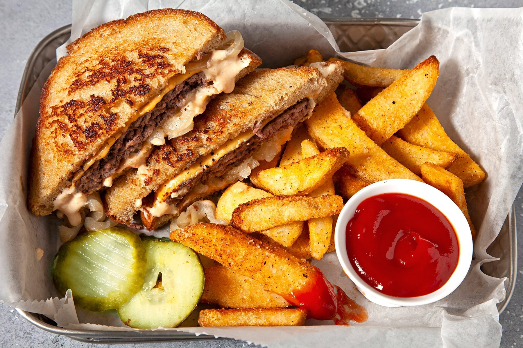 overhead shot; Patty Melts served with potato wedges and ketchup;